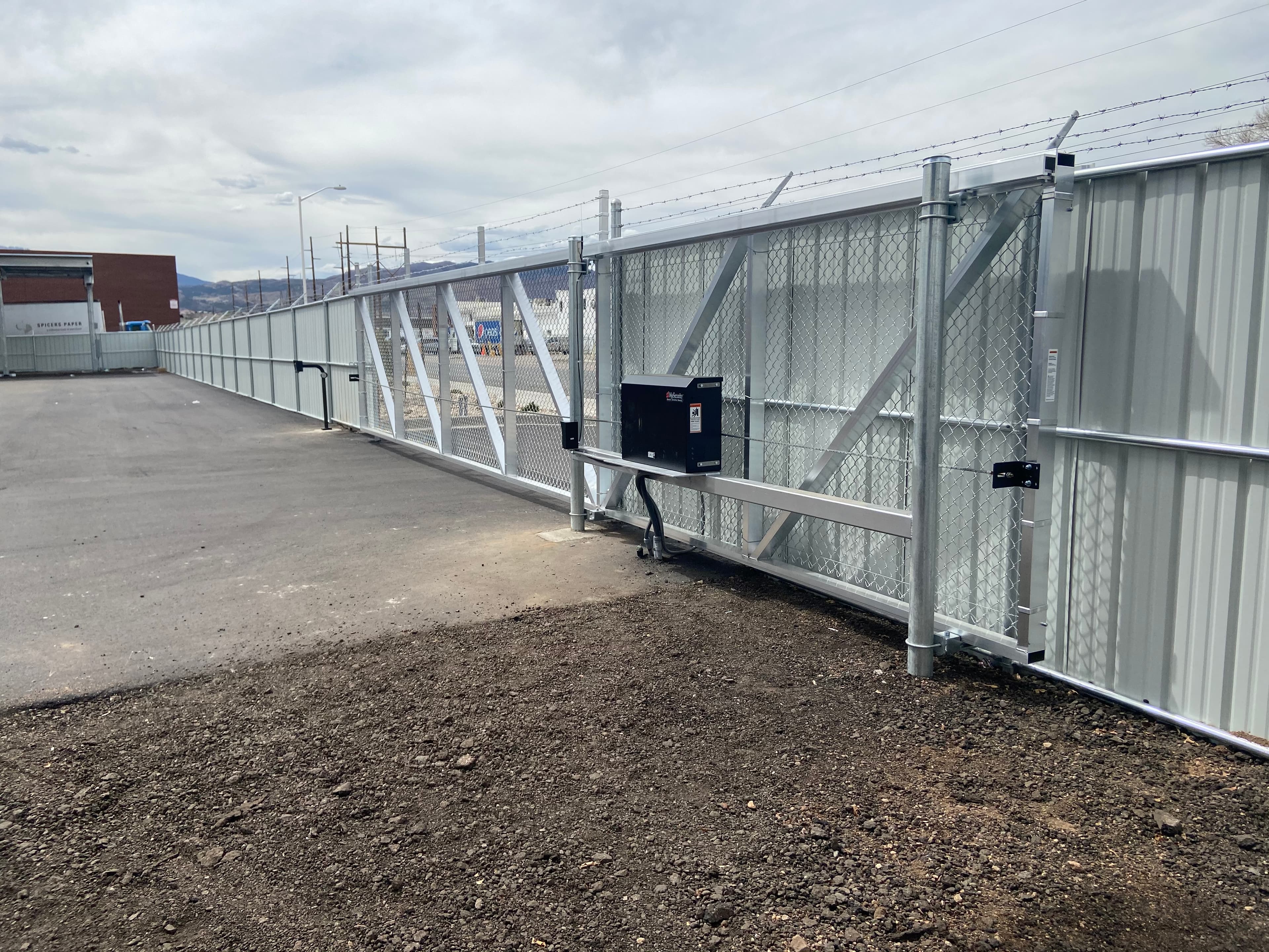 Aluminum enclosed-track cantilever gate with chain-link infill and barbed wire in Colorado Springs, CO